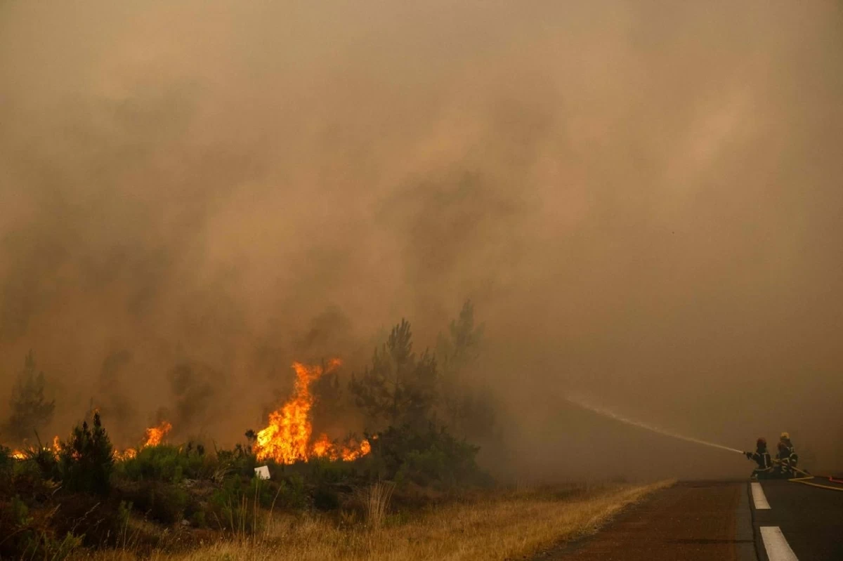 Firefighters spray water along the edge of a forest during a wildfire near the town of Lege-Cap-Ferret, in southwestern France on July 25, 2026
(AFP photo)