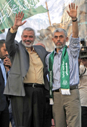 This file photo taken on October 21, 2011 shows then Hamas leader Ismail Haniyeh (left) and freed Palestinian prisoner Yahya Sinwar (right), a founder of Hamas’ military wing, waving as supporters celebrate the release of hundreds of prisoners following a swap with captured Israeli soldier Gilad Shalit in Khan Younis, southern Gaza Strip (AFP photo)