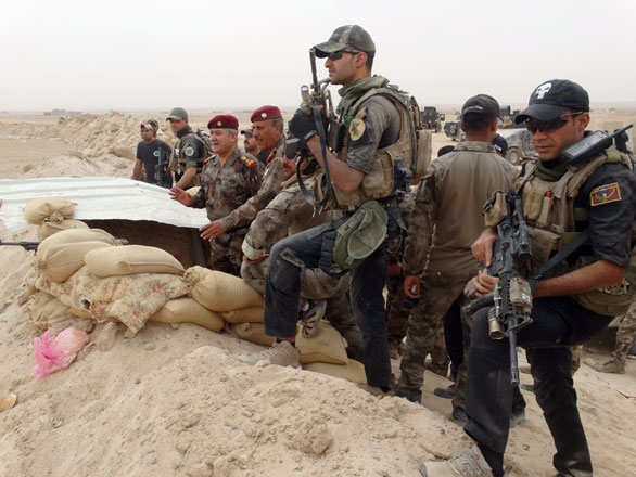 In this Tuesday photo Iraqi anti-terrorism forces watch enemy movements after regaining control of the Ramadi Stadium and the neighbouring Al Bugleeb area (AP photo)