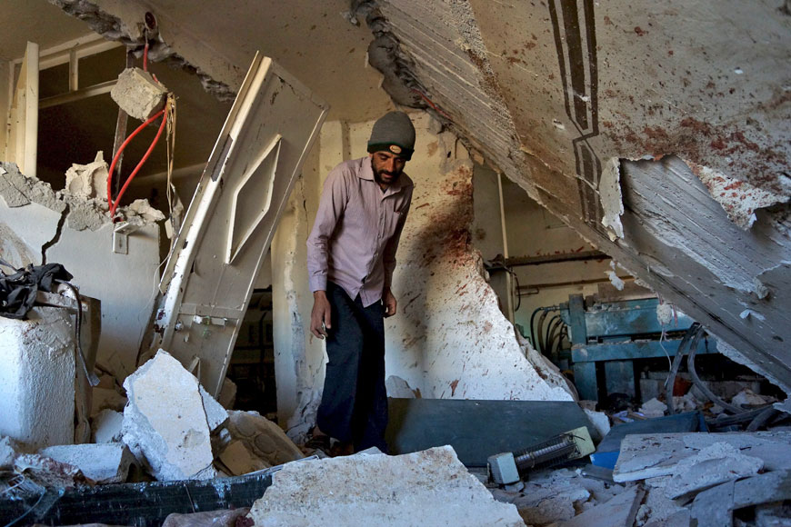 A man inspects the damage as bloodstains cover the walls inside an olive press factory after what activists said was shelling by forces loyal to Syria’s President Bashar Assad in the Sheikh Maskin town, north of Daraa, Syria, on Friday (Reuters photo)