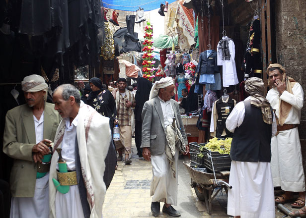 Yemenis walk past stalls at a market in the capital Sanaa’s old city on Monday (AFP photo)