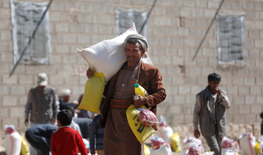 A displaced man who fled Saada province, northwest of Sanaa, carries relief supplies to his family during a food distribution by Yemeni volunteers in Sanaa, Yemen, Thursday (AP photo)