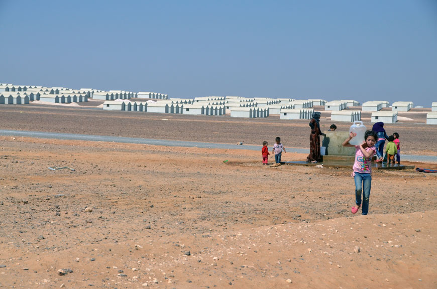 In this file photo, Syrian refugees fill water from taps located outside the Azraq camp (Photo by Muath Freij)