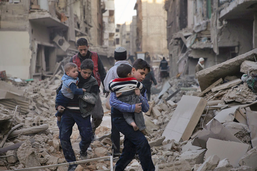 Youths carry children through a site damaged from what activists said was shelling by forces loyal to Syria’s President Bashar Assad in the town of Douma, eastern Ghouta in Damascus, Syria, on Wednesday (Reuters photo)