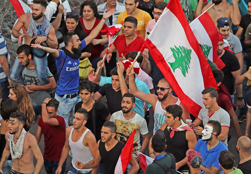 Lebanese anti-government protesters wave Lebanese flags as they shout slogans during a demonstration against the trash crisis and government corruption, in downtown Beirut, Lebanon, Saturday (AP photo by Hussein Malla)