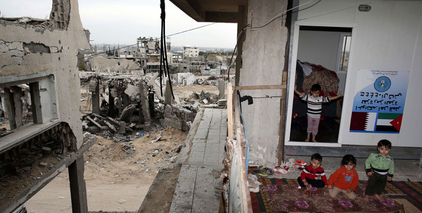 Palestinian kids sit inside their destroyed family home, which they fitted with 3 portacabins, in the eastern Gaza City Shejaiya neighbourhood, on May 11 (AFP photo)