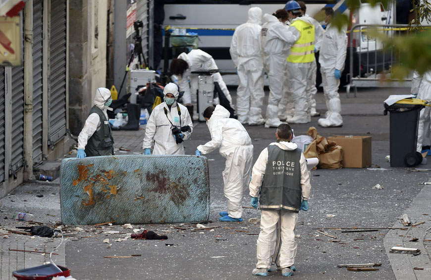 Forensic agents of the French police search for evidences outside a building in the northern Paris suburb of St Denis, on Wednesday, where French police special forces raided an appartment, hunting those behind the attacks that claimed 129 lives in the French capital on Friday (AFP photo)