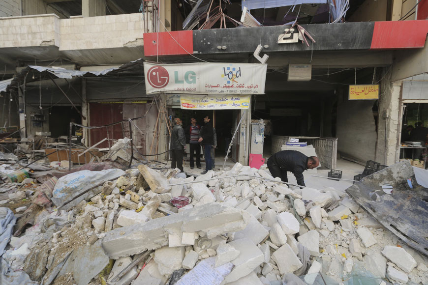 Men inspect the damage at a site hit by what activists said were air strikes carried out by the Russian air force on a busy marketplace in the town of Ariha, in Idlib province, Syria, on Sunday (Reuters photo)