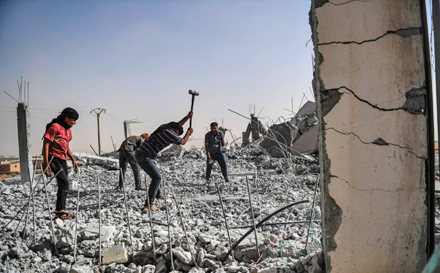 Syrians clear up the rubble of their houses that were destroyed during clashes on the outskirts of Raqqa, on Wednesday, as Syrian Democratic Forces, a Kurdish-Arab alliance, are battling to retake the city from Daesh group fighters (AFP photo)