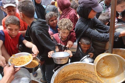 Caption: Palestinian children queue for a hot meal at a charity kitchen in Gaza City on April 30, 2025 (AFP photo)