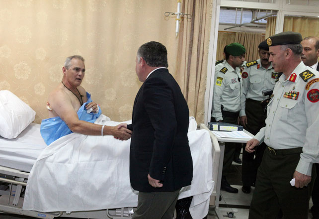 His Majesty King Abdullah checks on one of the victims who was injured in Monday’s shooting at a police training centre in east Amman, during a visit to the King Hussein Medical City (Photo courtesy of Royal Court)