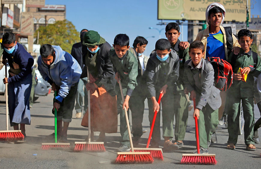 Yemeni students clean a street as they participate in a cleanup campaign in Sanaa, Yemen, Saturday (AP photo)