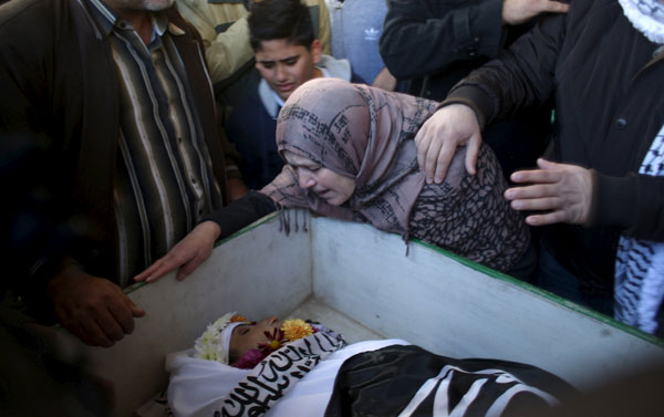 A relative of Palestinian Ishaq Badran, who allegedly carried out an attack against Israelis, mourns as she looks at his body, after it was released by Israel, during his funeral in the West Bank city of Ramallah  on Tuesday (Reuters photo by Mohamad Torokman)