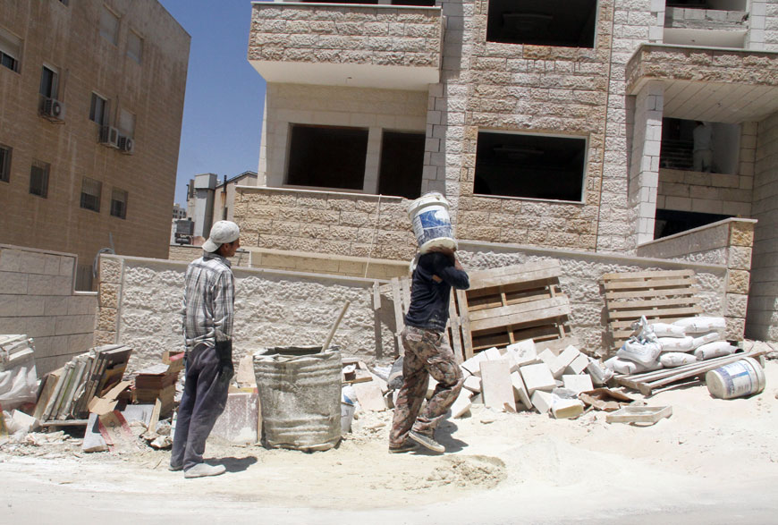 Workers are seen at a construction site in Amman on Thursday (Photo by Osama Aqarbeh)