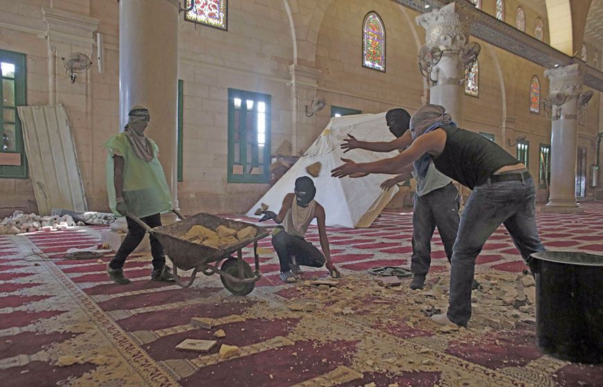 Masked Palestinians prepare stones inside Jerusalem’s Al Aqsa Mosque, one of Islam’s holiest sites, on Sunday, as they plan to remain inside to protect it in case of clashes. Muslims have been alarmed by an increase in visits by Jews and fear rules governing the compound will be changed (AFP photo)