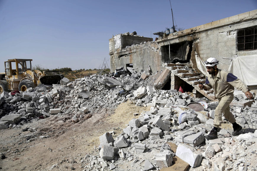 A civil defence member walks on the rubble of a damaged building next to a site hit by what activists said were air strikes carried out by the Russian air force at Ehsim town in the southern countryside of Idlib, Syria, on Saturday (Reuters photo)