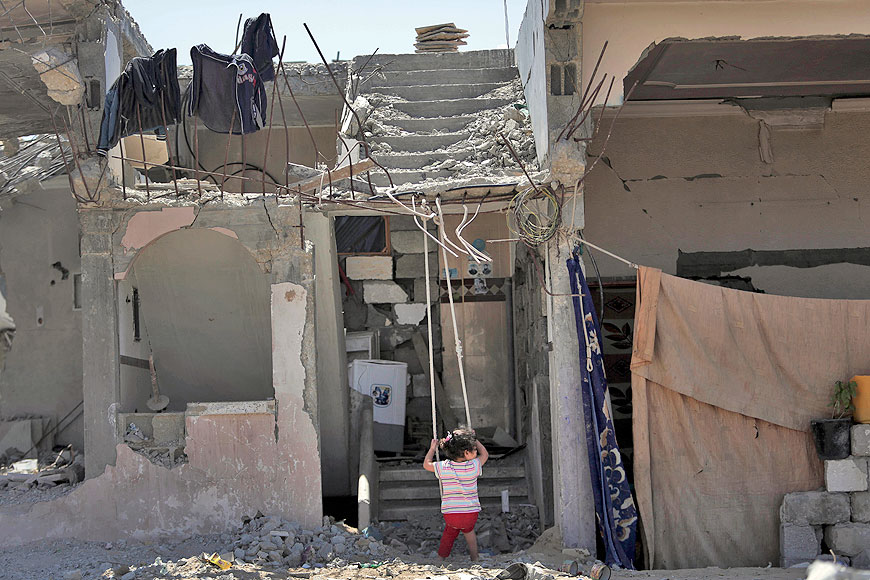 A Palestinian girl swings at the entrance of the family’s destroyed house in Gaza city on June 17 (AP file photo )
