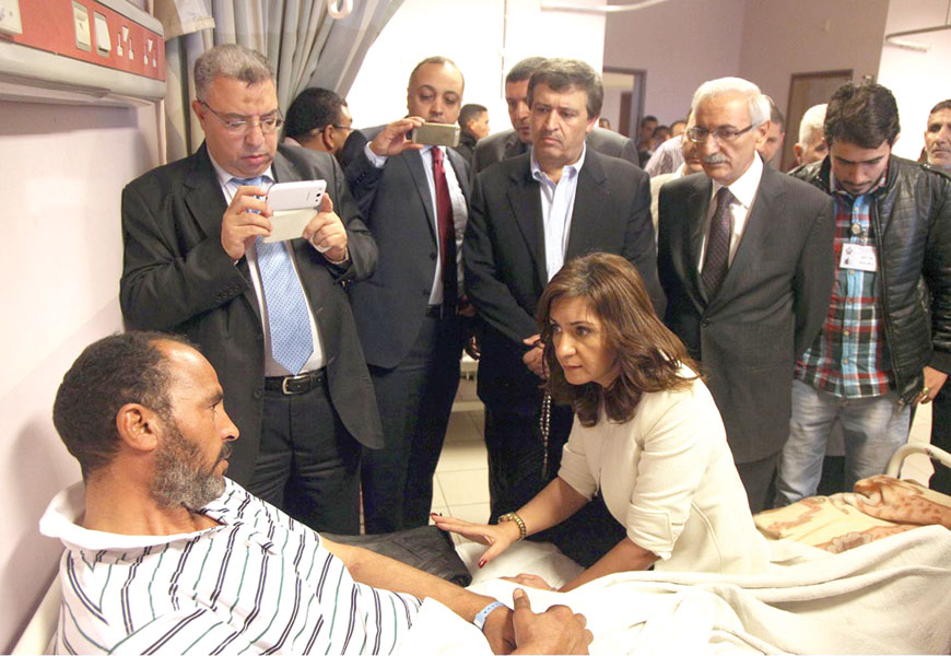 Labour Minister Nidal Katamine (2nd right standing), and Egyptian Minister of Immigration and Egyptian Expatriate affairs Nabila Makram (sitting) check on Wednesday on a man injured in an accident at the Amman Customs Department premises two days earlier (Petra photo)
