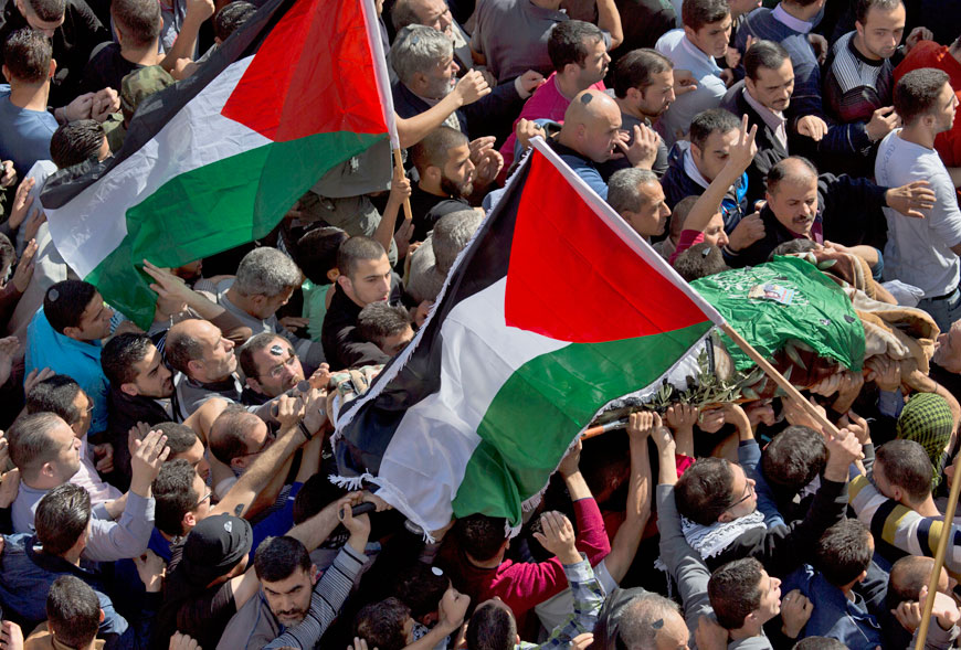 Palestinian mourners carry the body of Dania Ersheed, 17, during a mass funeral in the West Bank city of Hebron, Saturday. Mourners held a mass funeral for five Palestinians from Hebron who were killed after allegedly stabbing Israelis, as their bodies were released by Israeli troops last night (AP photo by Nasser Nasser)