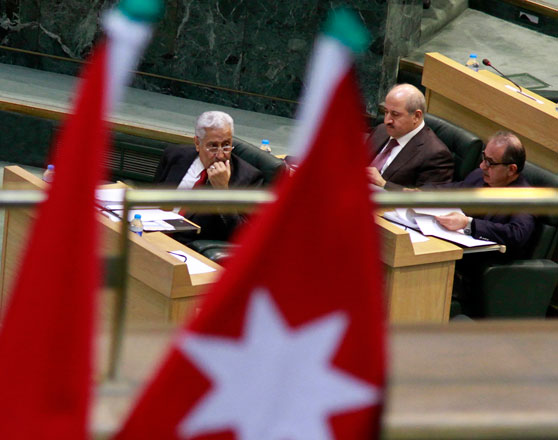 Prime Minister Abdullah Ensour (left) is seen behind the Jordanian flag as he listens to MPs' remarks during a Lower House session on Tuesday   (Photo by Osama Aqarbeh)