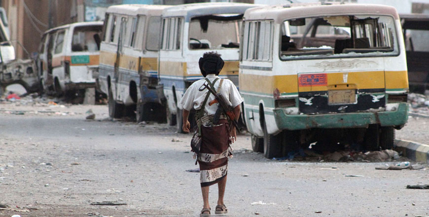 A Yemeni fighter loyal to exiled president Abed Rabbo Mansour Hadi walks on a damaged street in the Dar Saad suburb of the southern city of Aden on Wednesday (AFP photo)