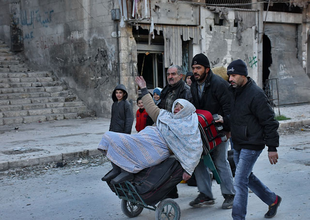Syrian residents fleeing the violence in the eastern rebel-held parts of Aleppo evacuate from their neighbourhoods through Bab Al Hadid district after it was seized by government forces, on Wednesday (AFP photo)