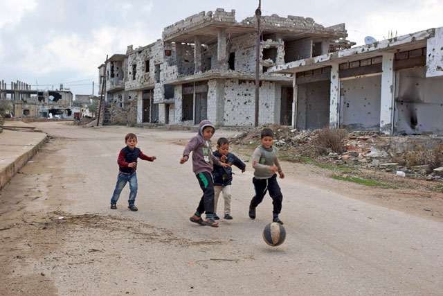 Children play near damaged buildings in the rebel-held historic southern town of Bosra Al Sham, Daraa, Syria, on Tuesday (Reuters photo)