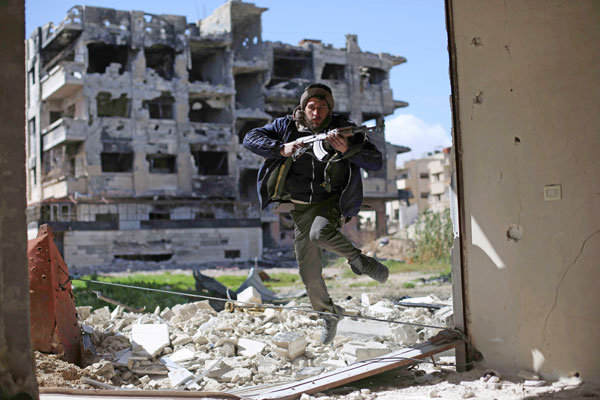 A fighter belonging to Jaish Al Islam runs to take cover near the frontline on Monday in the neighbourhood of Jobar, on the eastern outskirts of the capital Damascus (AFP photo)