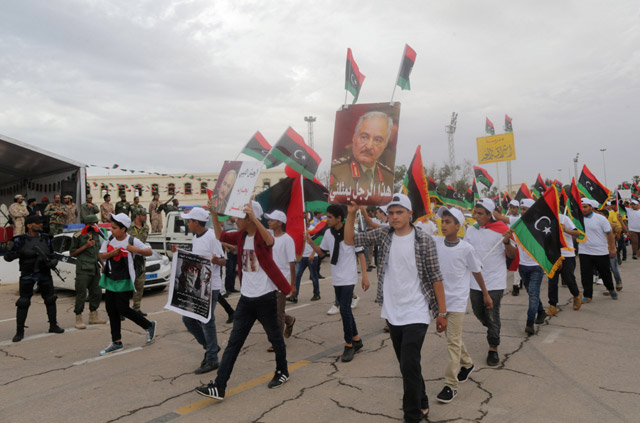 A youth holds a poster of Libyan military commander Khalifa Haftar during celebrations marking the third anniversary of Libyan National Army’s Dignity operation against extremists  and other opponents, in Benghazi, Libya, on Tuesday  (Reuters photo)