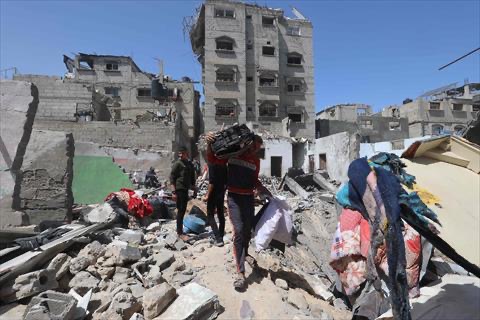 Palestinians salvage items from the rubble of a house that was destroyed in an Israeli airstrike in Khan Yunis in the southern Gaza Strip on March 31, 2025 (AFP photo)