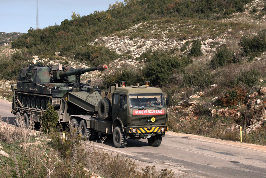 A Turkish army truck loaded with a tank  heading to the Syrian border near Yayladagi, Turkey, Wednesday (AP photo)