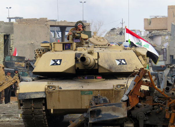 Iraqi counterterrorism forces drive a tank past rubble south of Anbar province’s capital Ramadi on Thrusday (AFP photo)