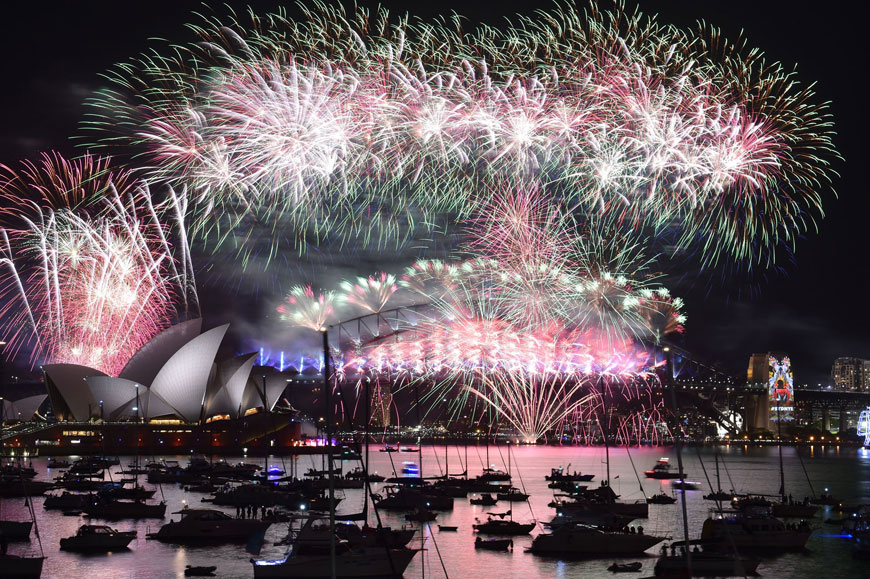 Fireworks light up the sky over Sydney’s Opera House (left) and Harbour Bridge during New Year celebrations in Sydney on January 1, 2016 (AFP photo)
