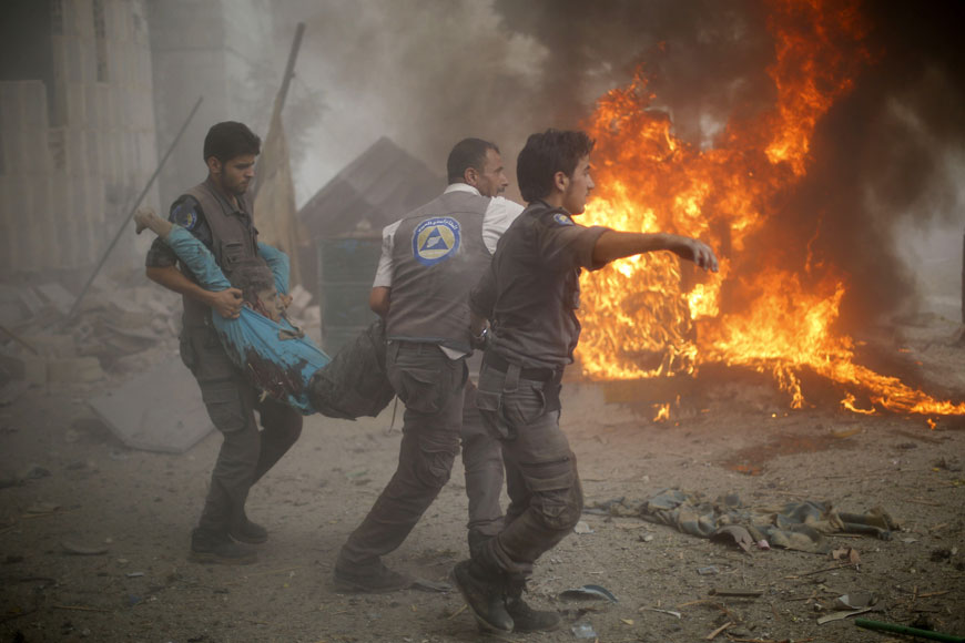 Syrian emergency personnel carry a wounded man following air strikes by Syrian government forces on a marketplace in the rebel-held area of Douma, east of the capital Damascus, on Monday (AFP photo)