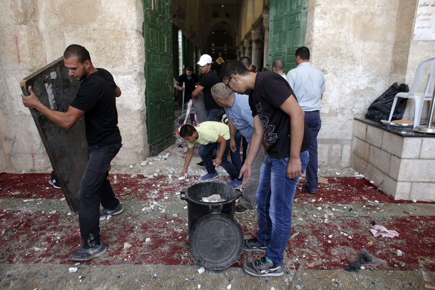 Palestinians clean up debris inside Al Aqsa Mosque in Jerusalem’s Old City after clashes at the compound between Palestinians and Israeli forces on Sunday, just hours before the start of the Jewish New Year (AFP photo)