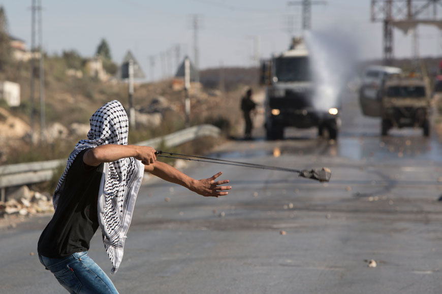 A Palestinian aims a sling shot at Israeli forces during clashes in Jalazoun refugee camp, near the West Bank city of Ramallah, on Friday (AP photo)