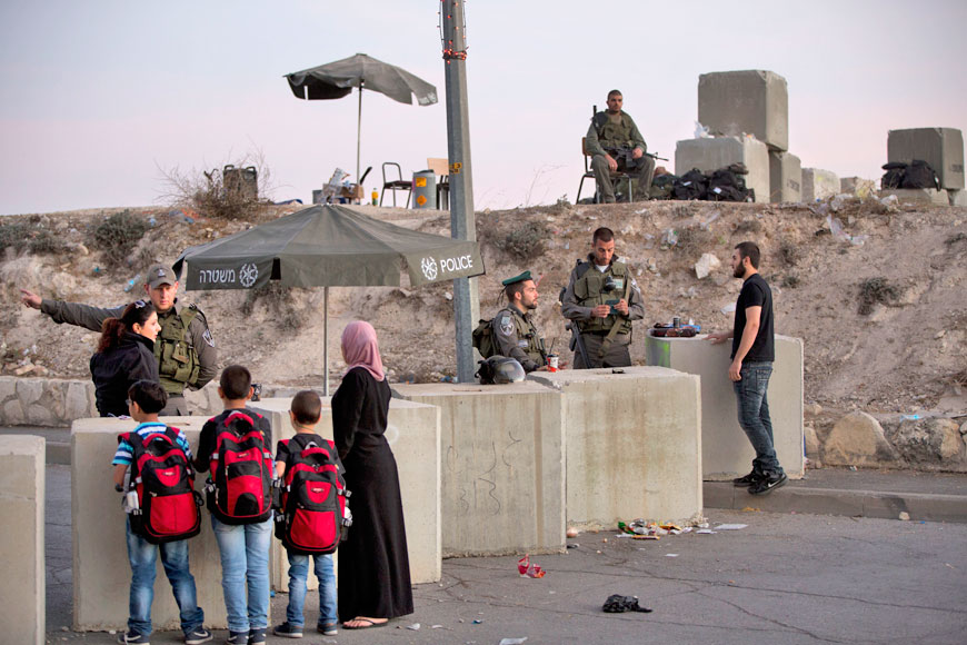 Israeli occupation forces check Palestinians’ identification cards at a checkpoint as they exit the Arab neighbourhood of Issawiyeh in occupied Jerusalem last Thursday (AP photo)