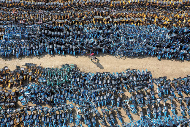 This aerial photo taken on Tuesday shows abandoned public shared bicycles at a lot in Shenyang in China's north-eastern Liaoning province (AFP photo)