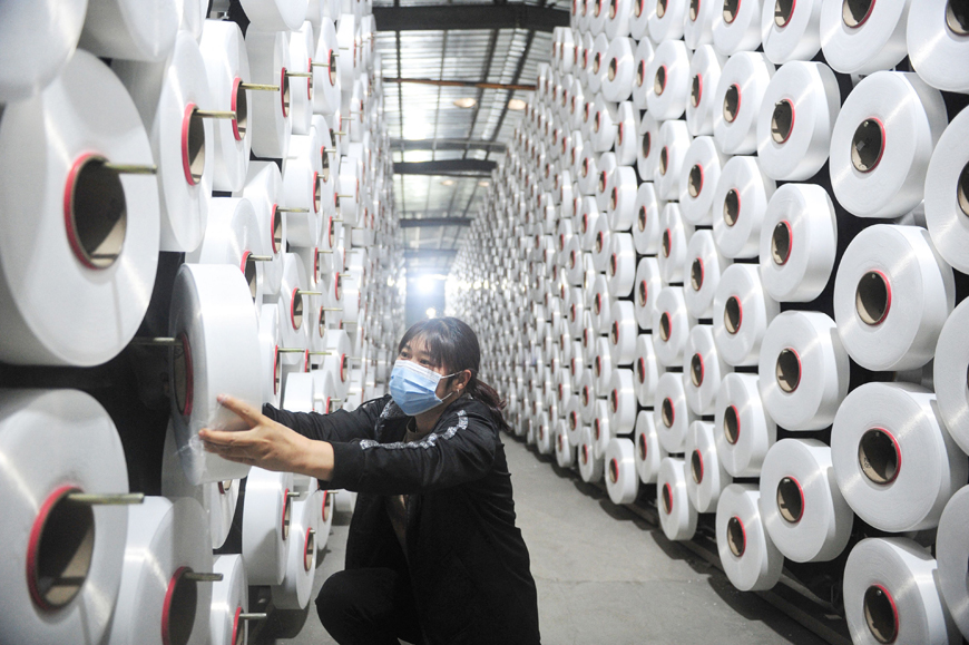 This photo taken on Sunday shows an employee working at a textile factory in Hangzhou in China's eastern Zhejiang province (AFP photo)