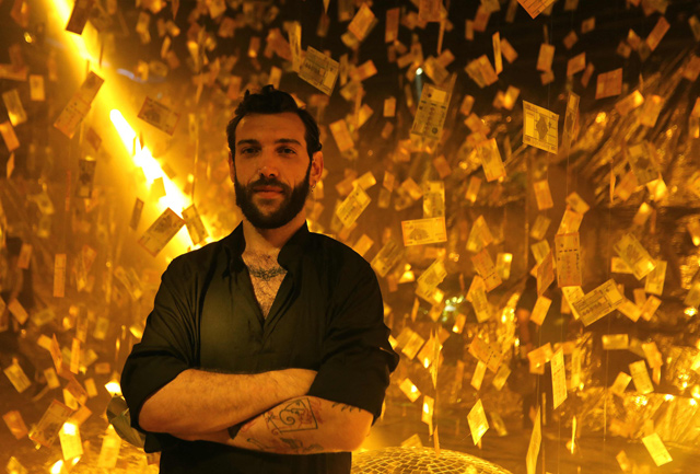 Lebanese artist Carlo Kassabian poses with his art installation titled 'Menhara' (collapsed) reflecting on the devaluation of the Lebanese pound, at a club in Beirut, on Saturday (AFP photo)