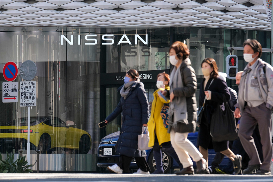 Pedestrians walk past the car showroom of Japan's Nissan Motor at Tokyo's Ginza district, on Tuesday (AFP photo)