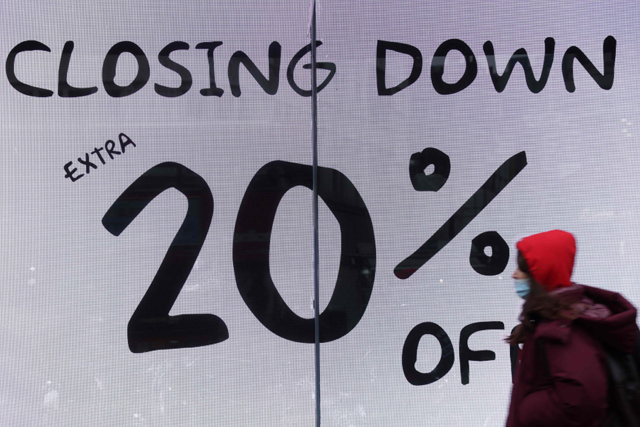 A shopper, wearing a facemask to combat the spread of COVID-19, passes a 'closing down sale' sign as she walks along Oxford Street in London on Tuesday (AFP photo)