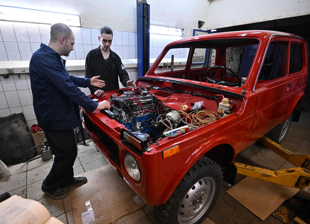 Sergei Diogrik (left), the head of the Lada History Club, and his assistant Kamil restore an 80s Lada Niva, a legendary four-wheel drive car, in their garage in Tolyatti, also known as Togliatti, on Thursday (AFP photo)