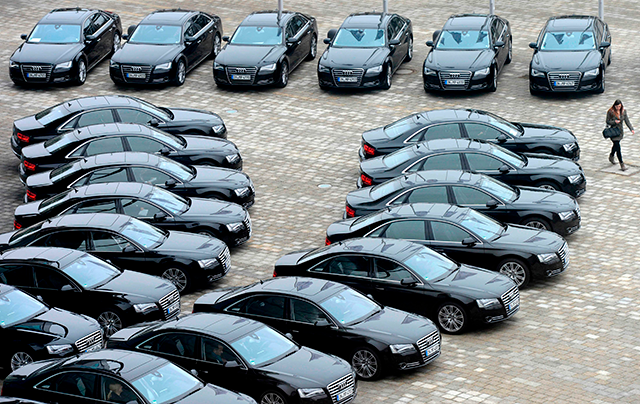 A woman walking past Audi cars standing in front of the German carmaker's headquarters in Ingolstadt, southern Germany, on March 12, 2013 (AFP file photo)