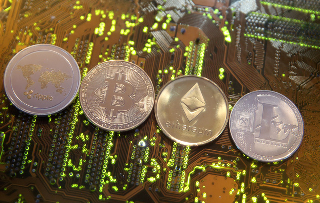 Representations of the Ripple, Bitcoin, Etherum and Litecoin virtual currencies are seen on a PC motherboard in this illustration picture, February 13 (Reuters file photo)