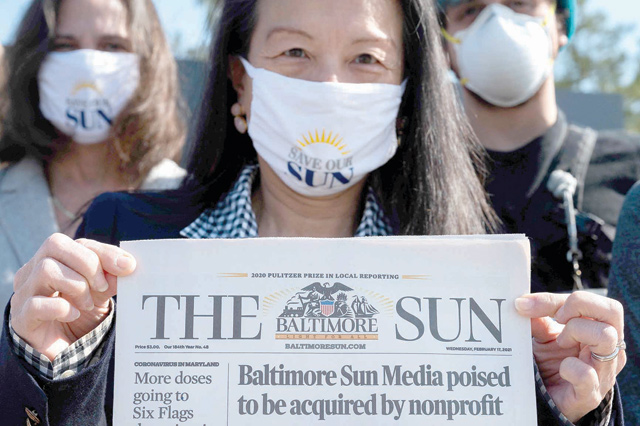 Baltimore Sun reporter Jean Marbella holds up the Baltimore Sun front page that headlined their potential take over by a non-profit group during an interview in Baltimore, Maryland ,on Friday (AFP photo)