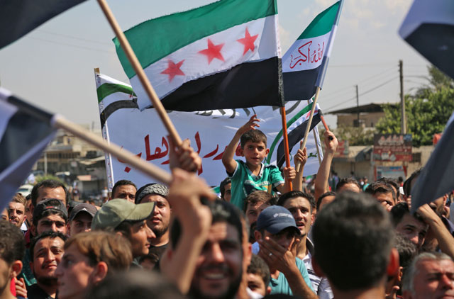 Syrians wave flags during a demonstration in the rebel-held northern Syrian city of Idlib on Friday in support of the agreement between Turkey and Russia, to avert an assault on Syria's last major rebel stronghold (AFP photo)