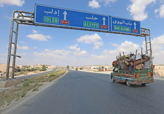 Residents of the Idlib province flee towards the Syrian-Turkish border on Monday (AFP photo)