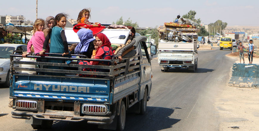 Syrians ride with their belongings in a pickup truck as they head to safer areas in the northern part of Syria's rebel-held Idlib province on Thursday (AFP photo)