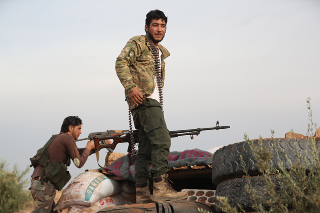 A Syrian rebel-fighter from the National Liberation Front gather on the frontline with regime forces in the southeast of Idlib province on Tuesday (AFP photo)
